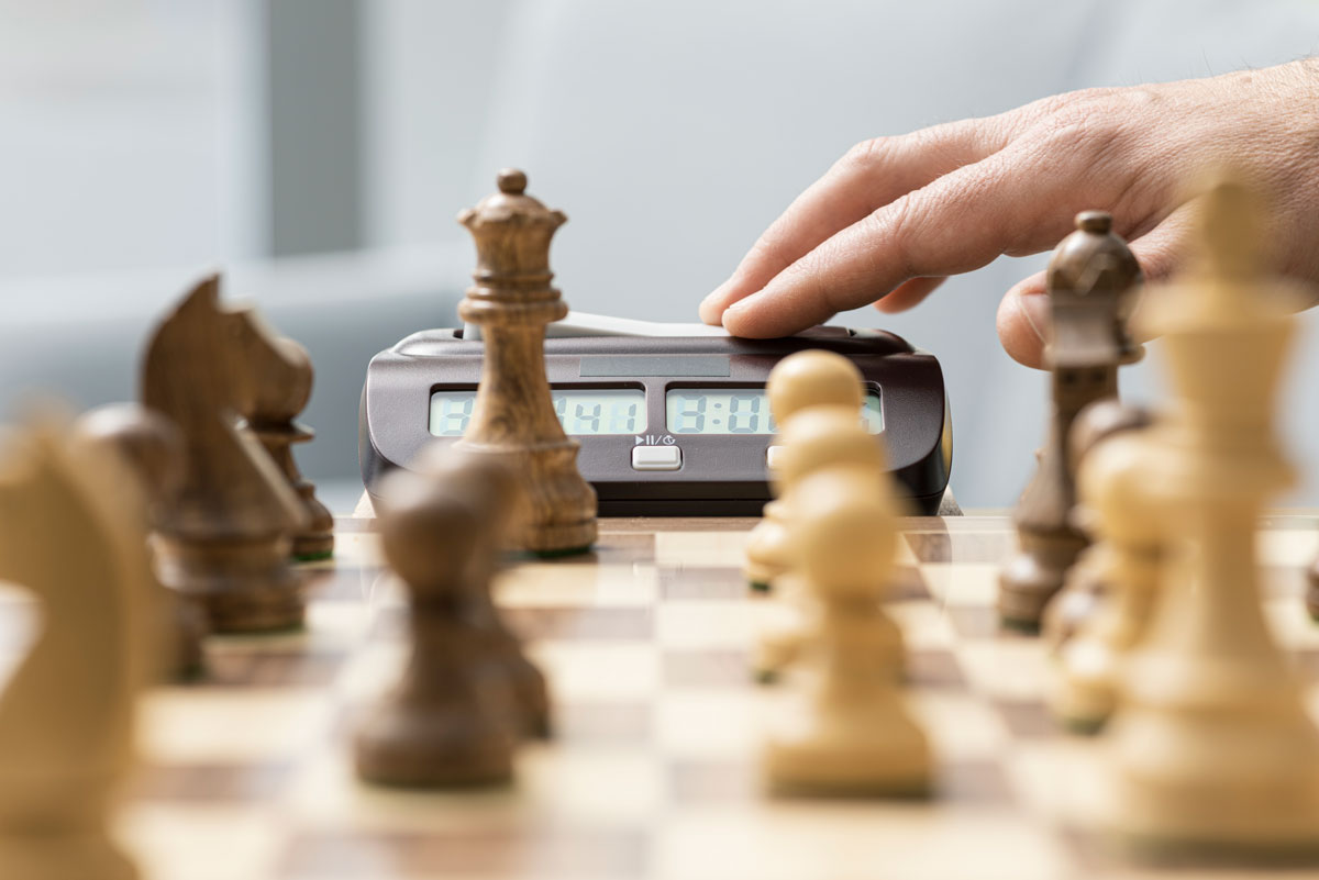 A hand pressing a chess clock during a blitz game